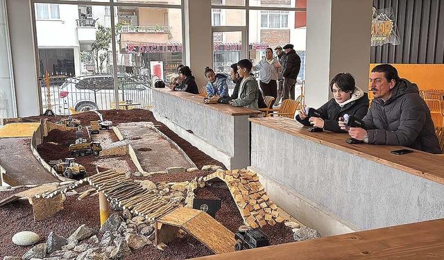 Bu kafenin müşterileri, minyatür inşaat sahasında iş makineleriyle oynuyor